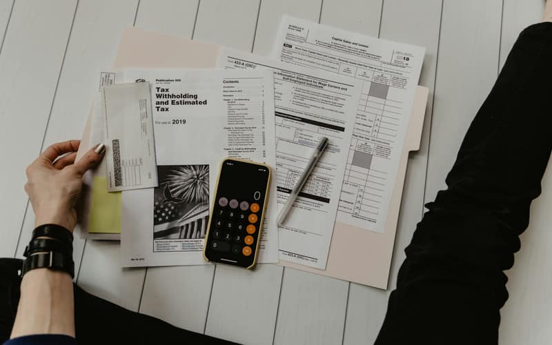 Printed financial documents and a calculator on a desk